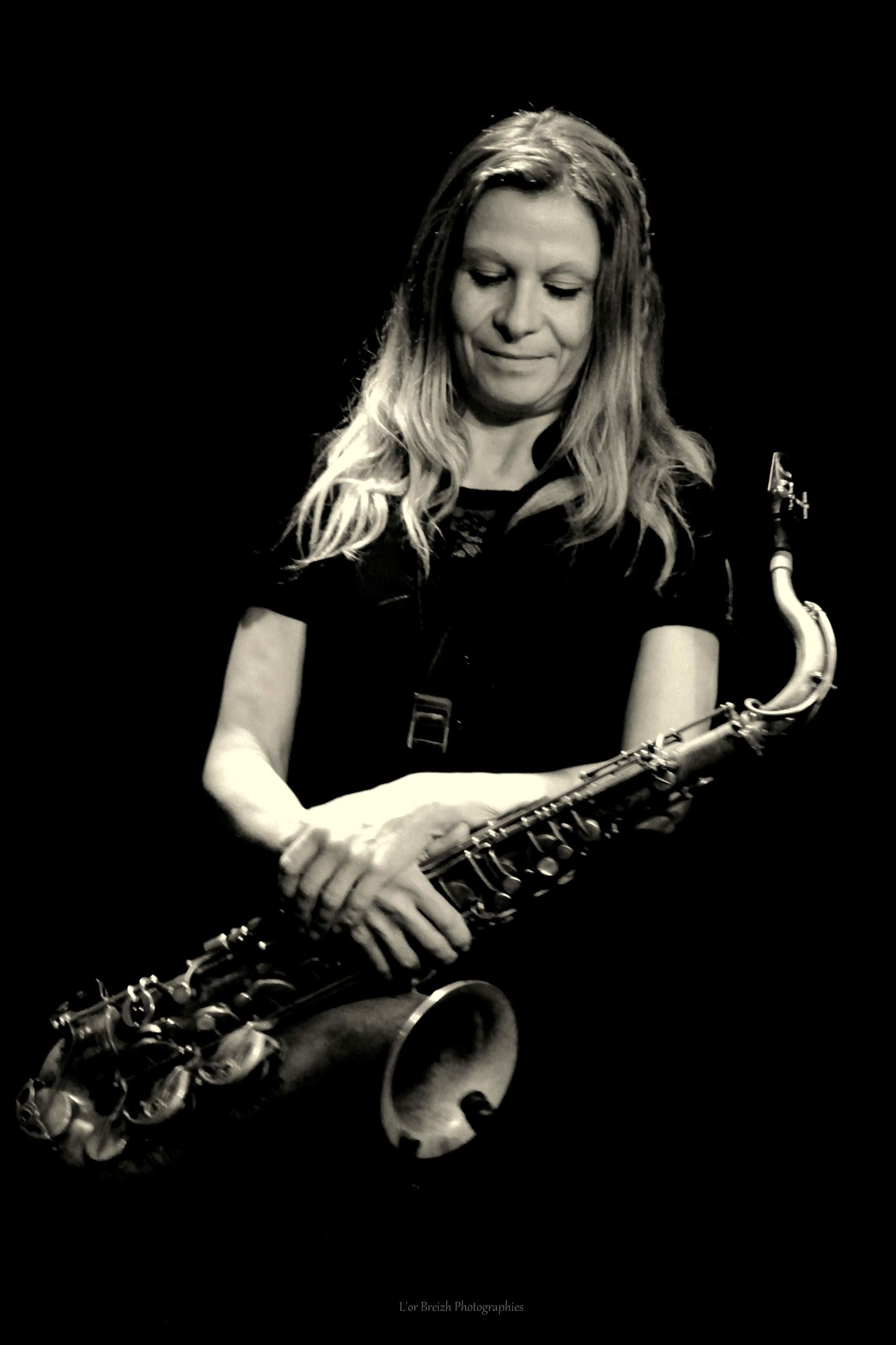 Séverine Éouzan, les yeux baissés, tient son saxophone ténor.